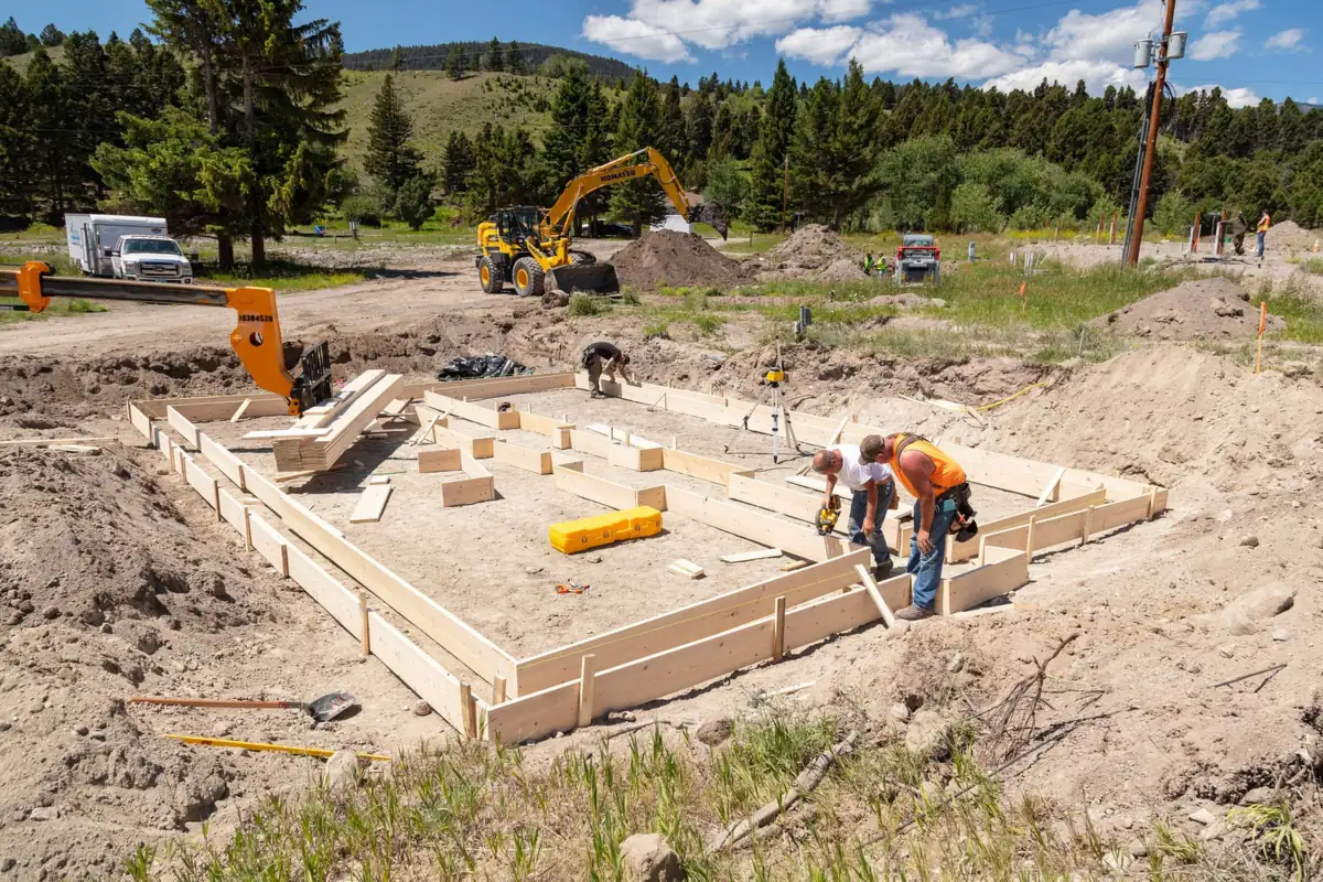 Crew building wood foundation forms for a small building on a graded pad