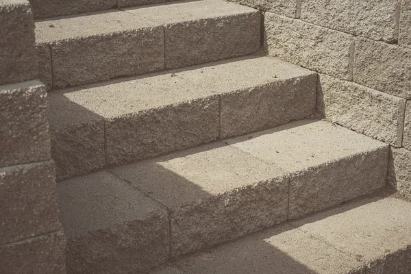 Concrete steps between block cheek walls in sunlight