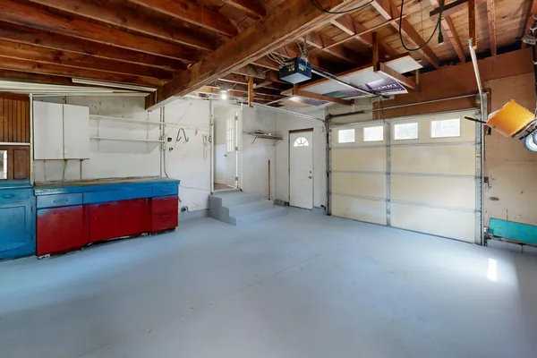 Empty two-car garage with a smooth gray concrete floor and built-in cabinets